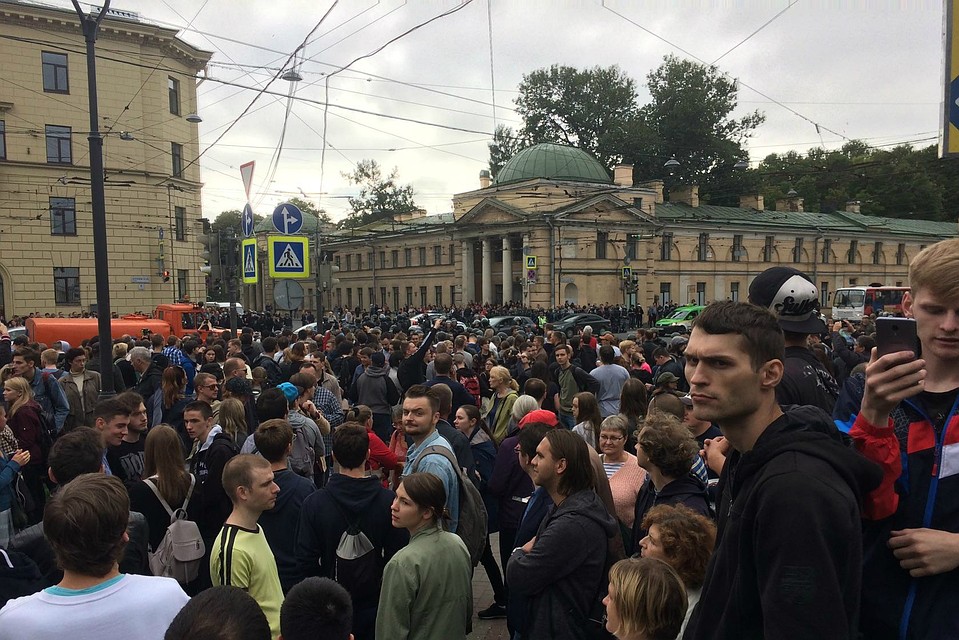 В руках у митингующих - плакаты и флаги