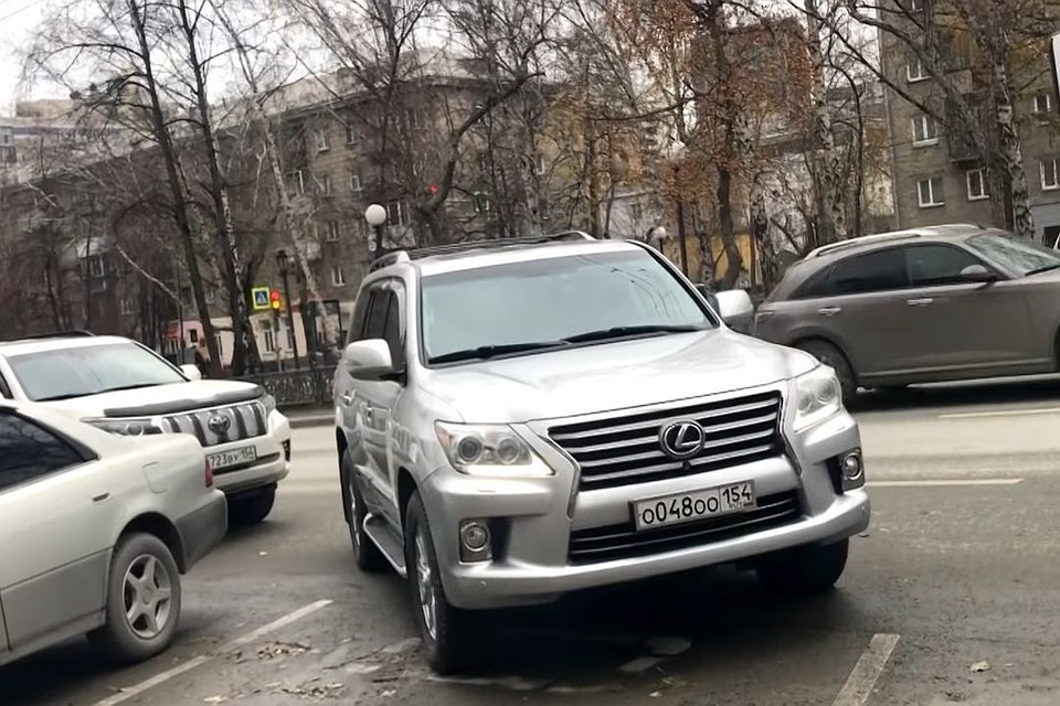 Депутатские "Лексусы" и "Камри" припарковались на местах для инвалидов и тротуаре. Стоп-кадр с видео канала на youtube.com "Новосибирский".