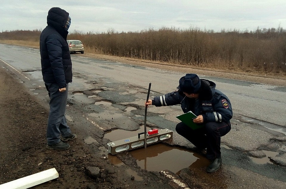 Ямы на дороге из Пскова в Гдов вместе с общественниками измерили сотрудники ГИБДД. Фото: Общественная организация "Убитые дороги. Псков".