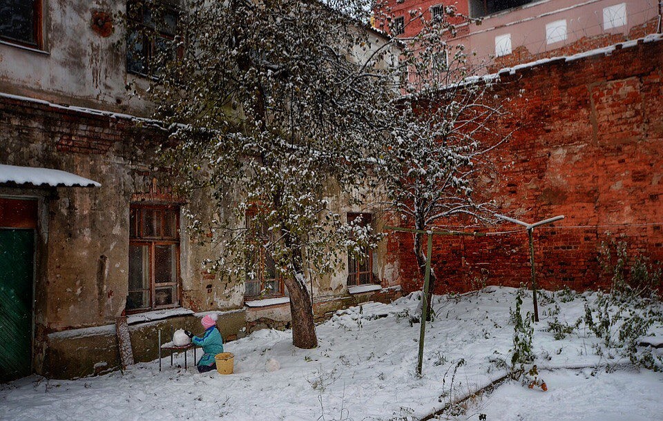 Маленькая девочка лепила снеговика у тюремной стены во дворе страшного одноподъездного дома с видом на окна камер и колючую проволоку. Фото: Виктор ГУСЕЙНОВ
