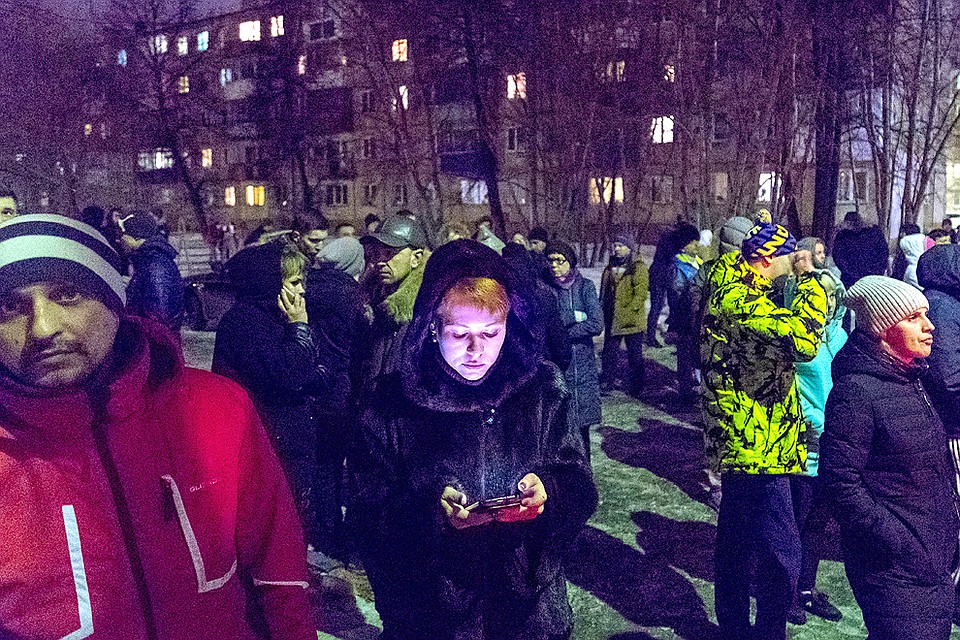 Собравшиеся у торгово-развлекательного центра "Зимняя вишня" следят за новостями. ФОТО Данил Айкин/ТАСС