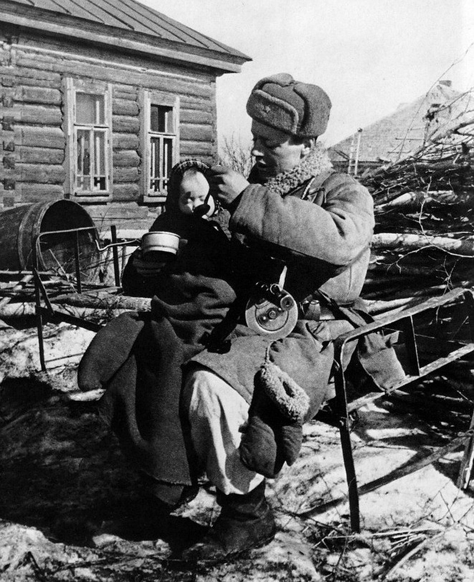 Всех угнали фашисты». Старший сержант Моисеев — командир отдельной артиллерийской разведки 2-го дивизиона 4-й батареи 308-го полка кормит двухлетнюю девочку Валю, найденную им в одной из пустых изб деревни Извеково. Смоленская область, Вяземский район, ма