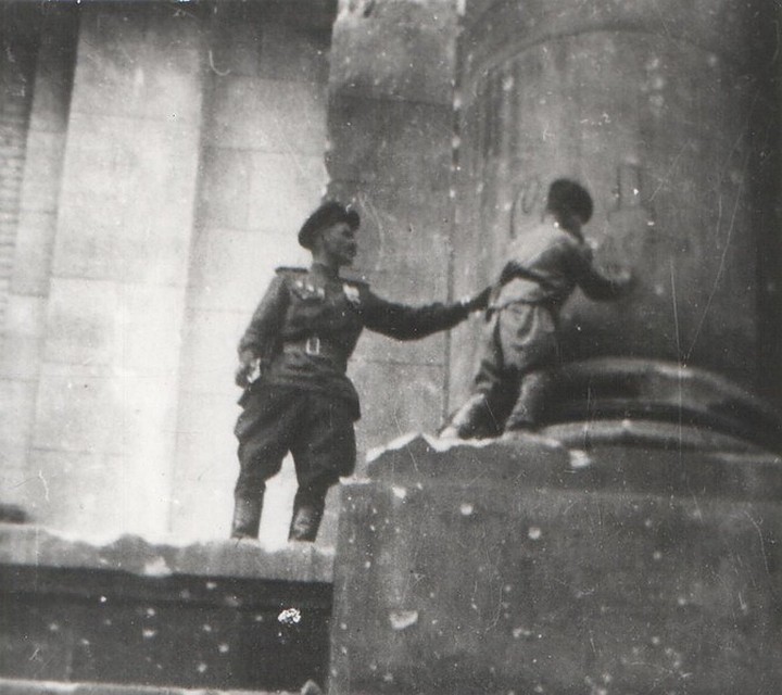 Сын полка Володя Тарновский ставит автограф на колонне Рейхстага. Май 1945.