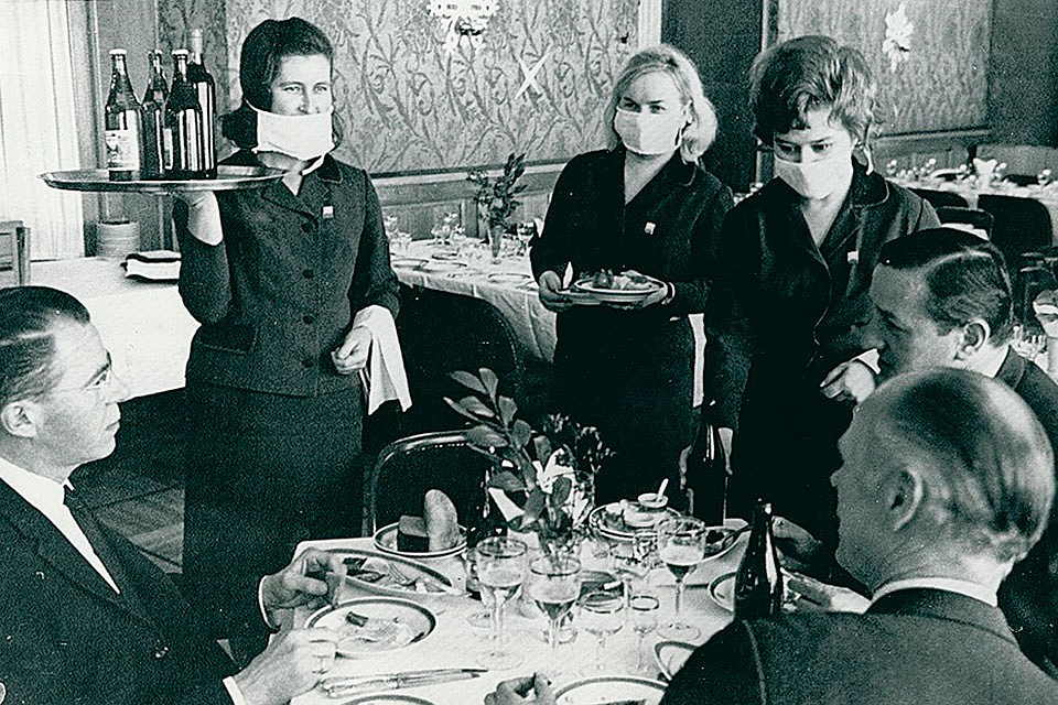 Фото, сделанное в 1969-м году, как будто из сегодняшней жизни. Официантки ресторана "Националь" в Москве обслуживают клиентов, надев маски. Фото: из коллекции Александра Васильева.